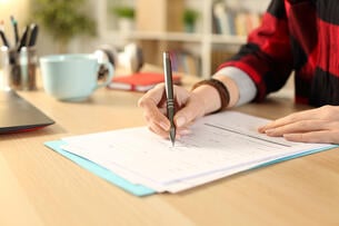 A student writes on a form. 