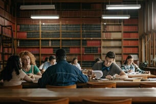Candid photo of group of friends studying in the library