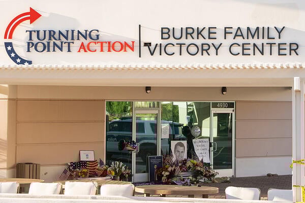 Photos of Charlie Kirk and flowers sit in front of the Turning Point USA headquarters