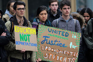 A group of students holds signs reading "education not deportation" and "united in justice for undocumented students."