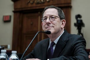 Michael Schill, a light-skinned man wearing glasses and a dark business suit, testifies at a hearing.