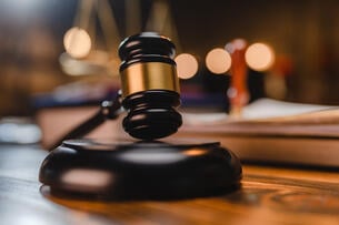 A gavel resting on a desk.